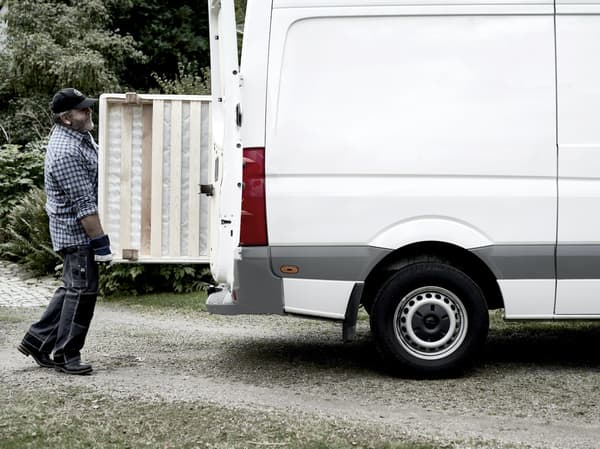 A man loading a white hire van from IKEA.