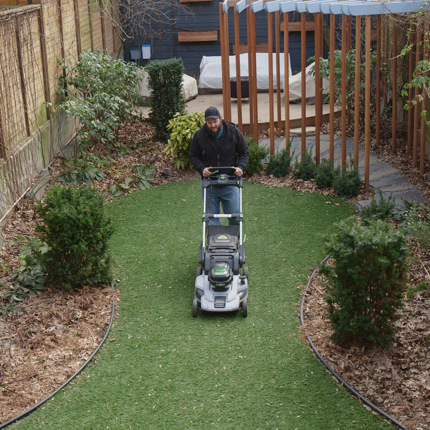 A man mowing the lawn in the garden.