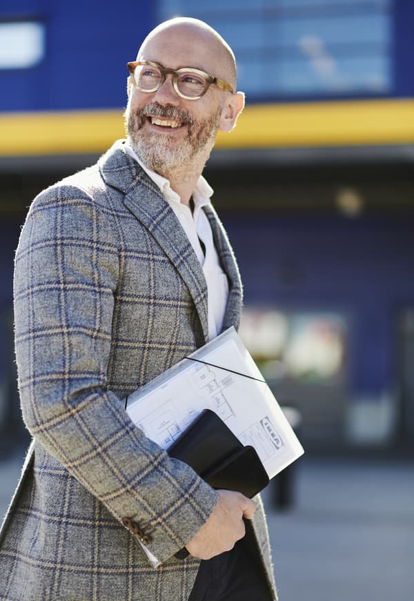 A man smiles in front of the ikea building entrance 