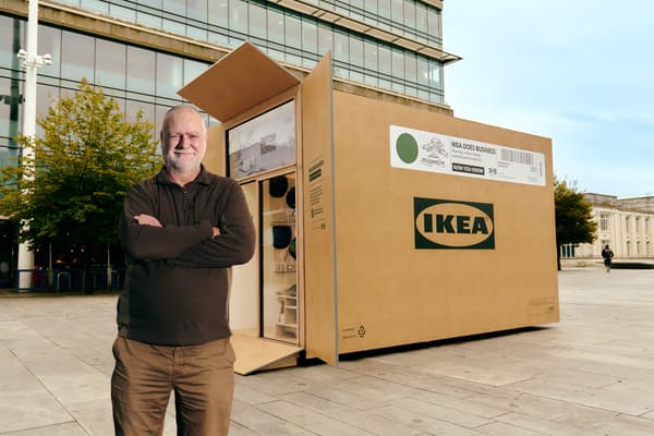 A man standing in front of an IKEA giant flatpack box