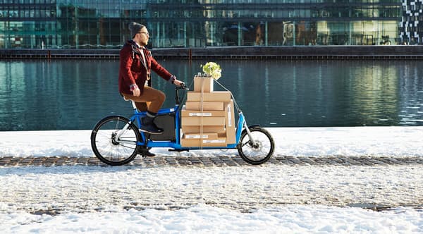 A man transporting IKEA boxes on a bicycle