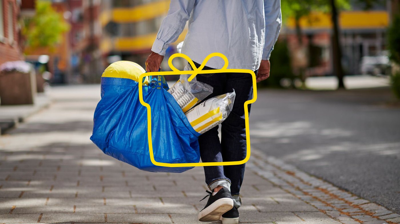 A man walks with a full FRAKTA bag. 