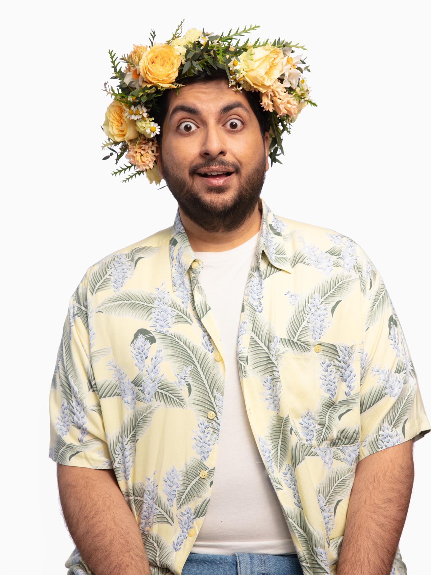 A man with a flower crown looking surprised
