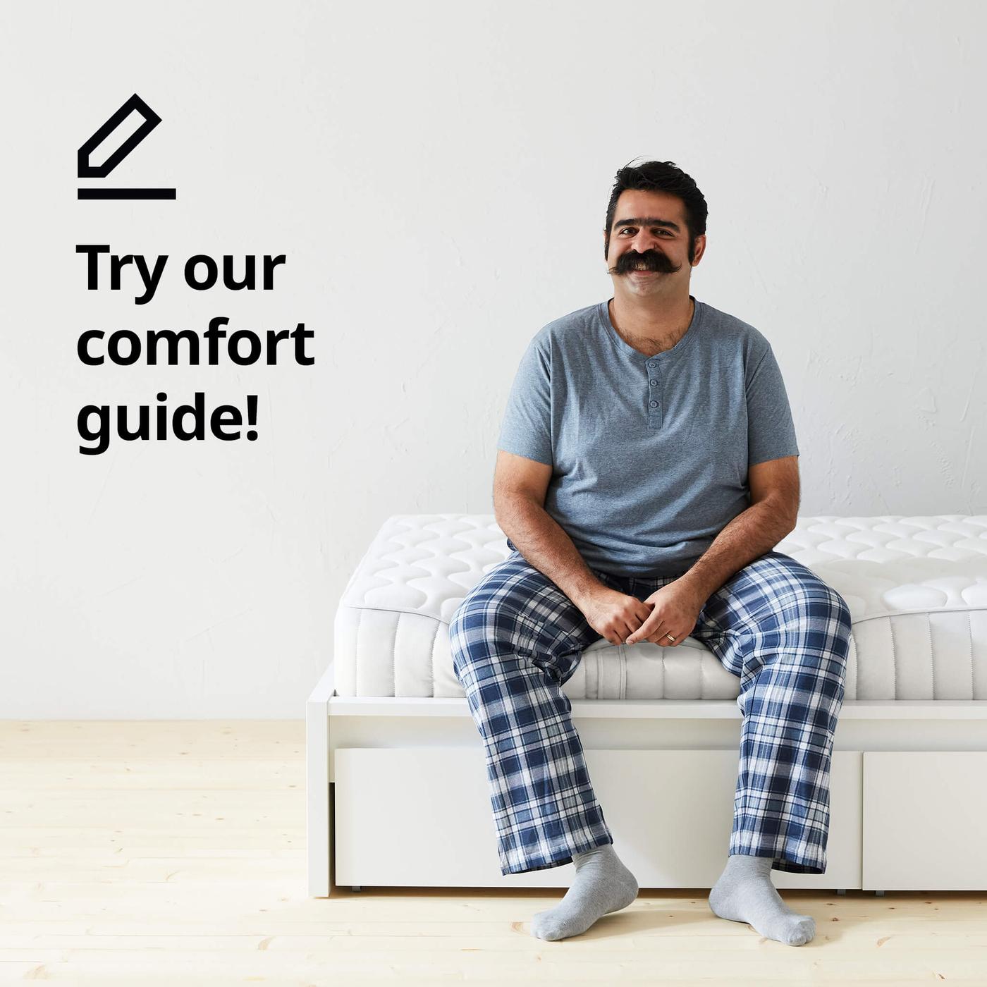 A man with a mustache, wearing a blue shirt and plaid pajama pants and the text 'Try our comfort guide!' on the image.