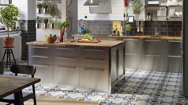 A matt white IKEA VOXTORP kitchen with island and wooden worktop.