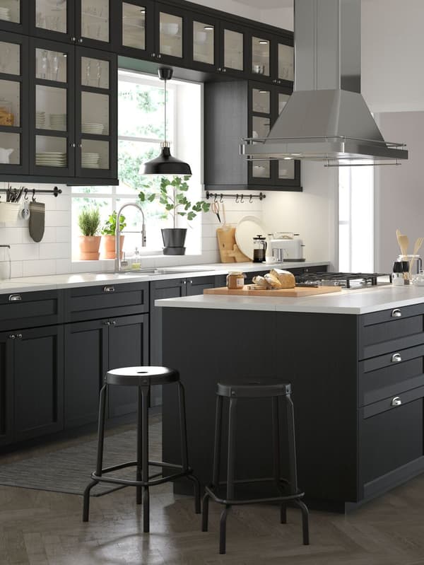 A medium sized black and white, traditional style kitchen with stained black LERHYTTAN cabinet doors.