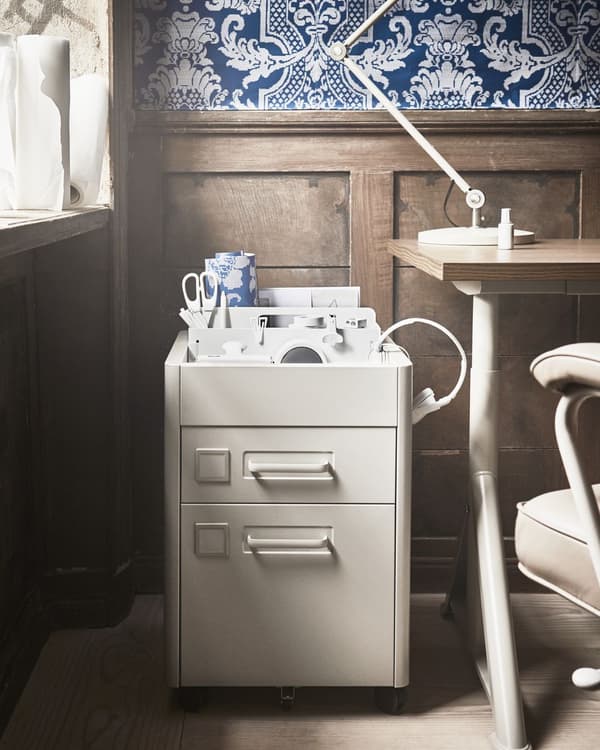 A metal drawer unit in beige with castors