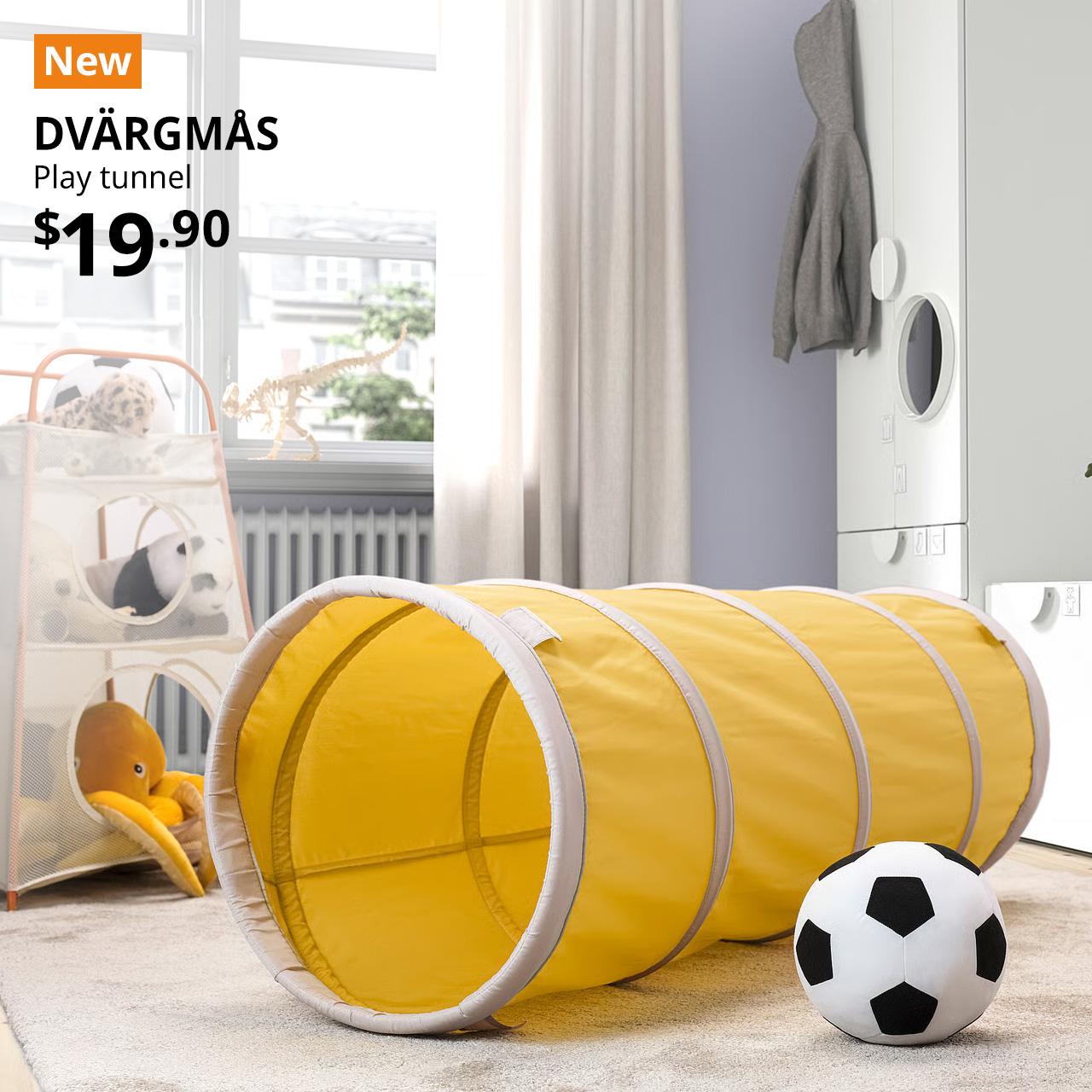 A mid shot of a children's room featuring a yellow/beige DVÄRGMÅS play tunnel placed in the middle of the room. On the top left corner, a orange tag with white text that reads 'New', followed by black text overlaying image that reads 'DVÄRGMÅS, Play tunnel, $19.90'.