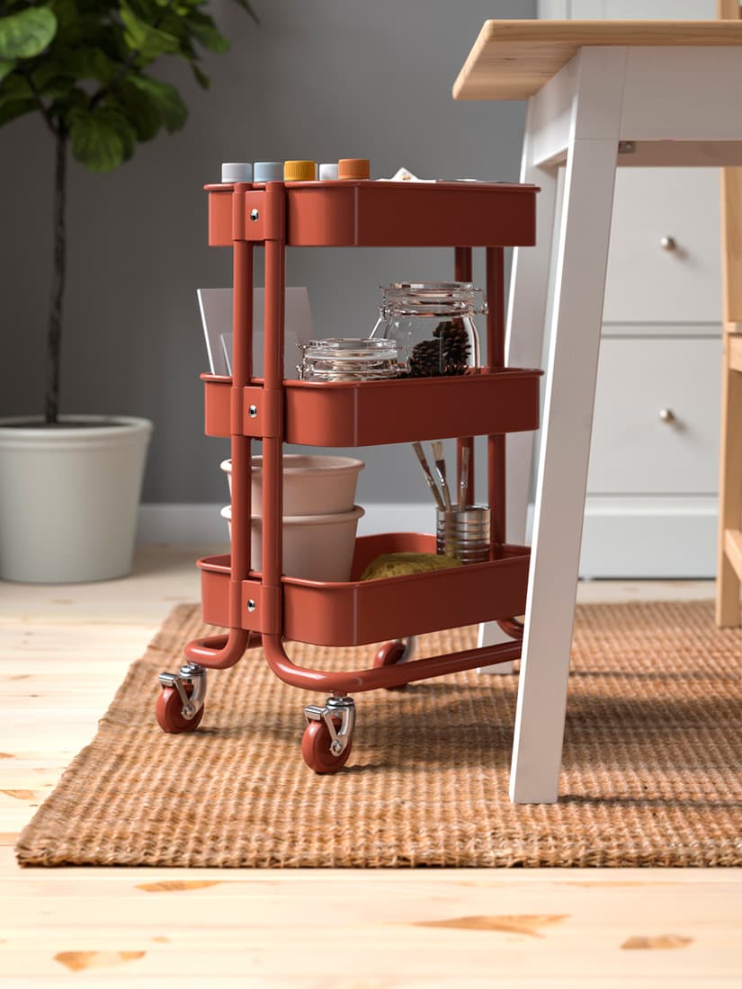 A mid shot of a red-brown RÅSKOG trolley in the dining room.