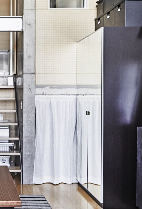 A mirrored wardrobe next to some stairs.