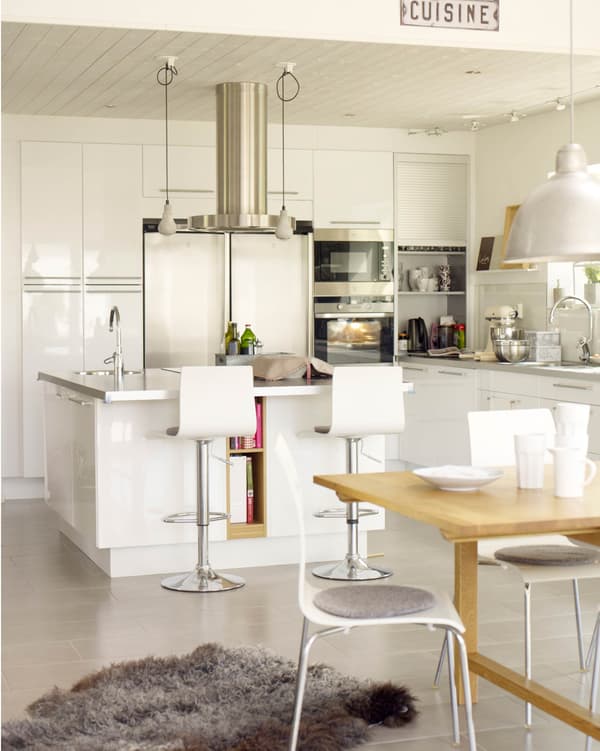 A modern high-gloss white kitchen with an island and open storage.