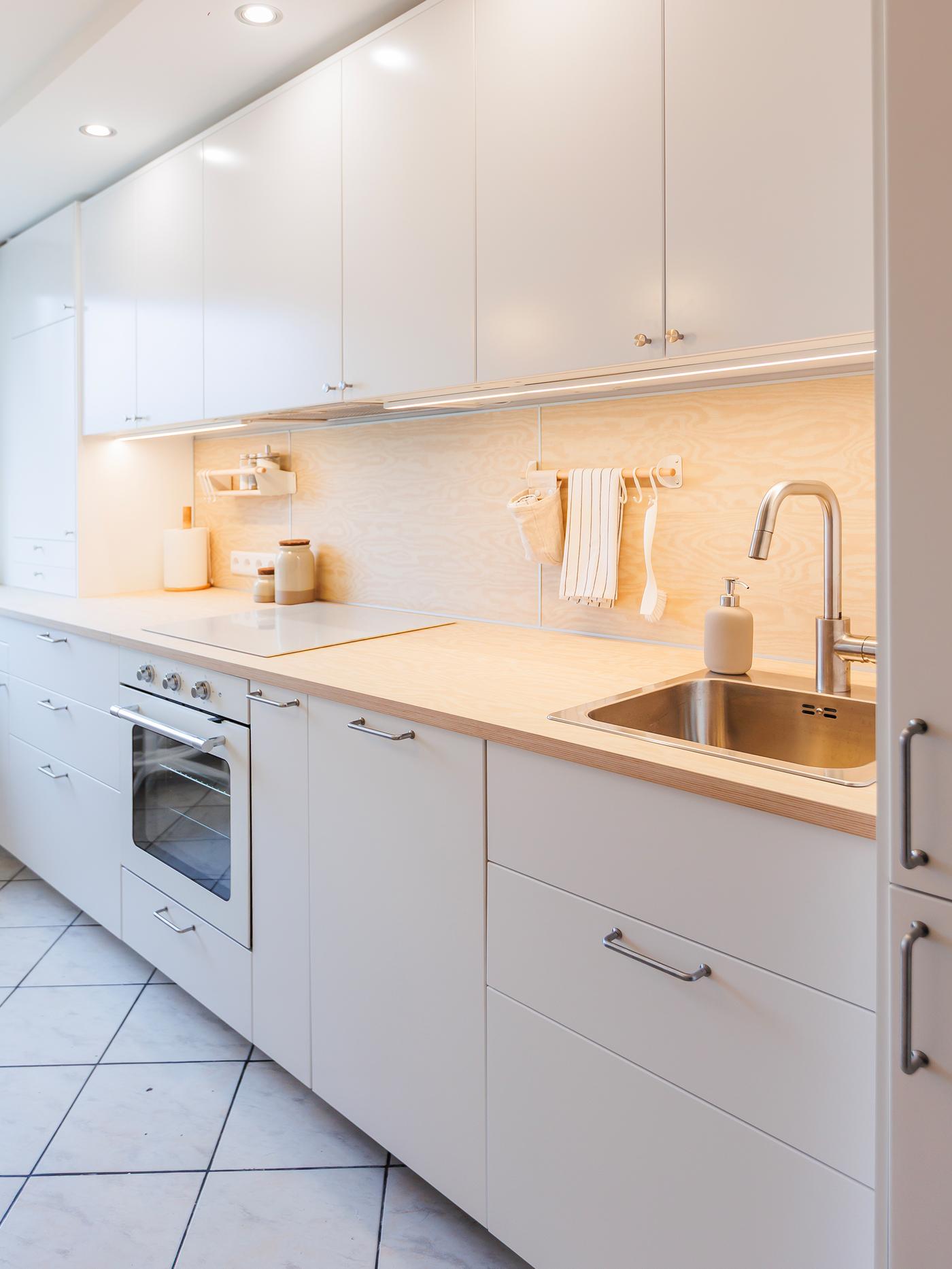 A modern kitchen with white VEDDINGE fronts arranged in a single line along the wall.
