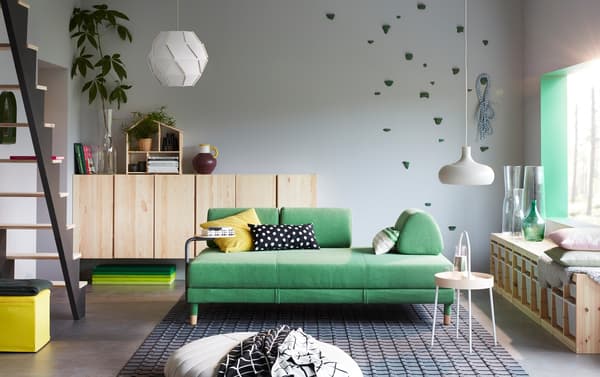 A modern living room with FLOTTEBO sofa-bed in birght green with a white BURVIK side table in the centre of the room.