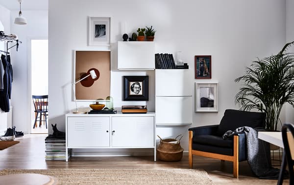 A modern living room with one wall furnished with three TRONES shoe cabinets aligned around a bench to create storage and focal points 
