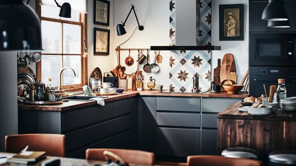 A modern METOD kitchen with dark grey fronts and a wooden worktop with a kitchen tile backsplash.