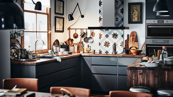 A modern METOD kitchen with dark grey fronts and a wooden worktop with a kitchen tile backsplash.