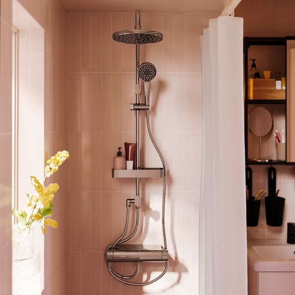 A modern shower with a large overhead showerhead, a handheld attachment and shelving for toiletries in a bathroom.