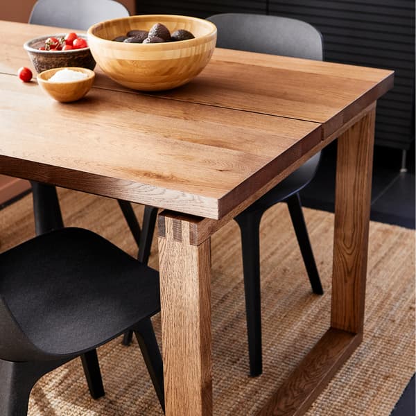 A MÖRBYLÅNGA table in brown stained oak veneer with bowls in bamboo on the table top.