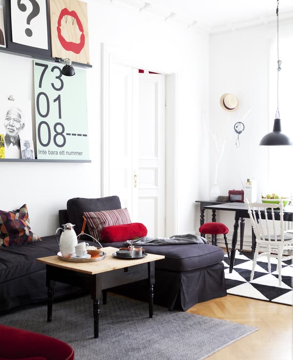 A monochrome room with red accessories.