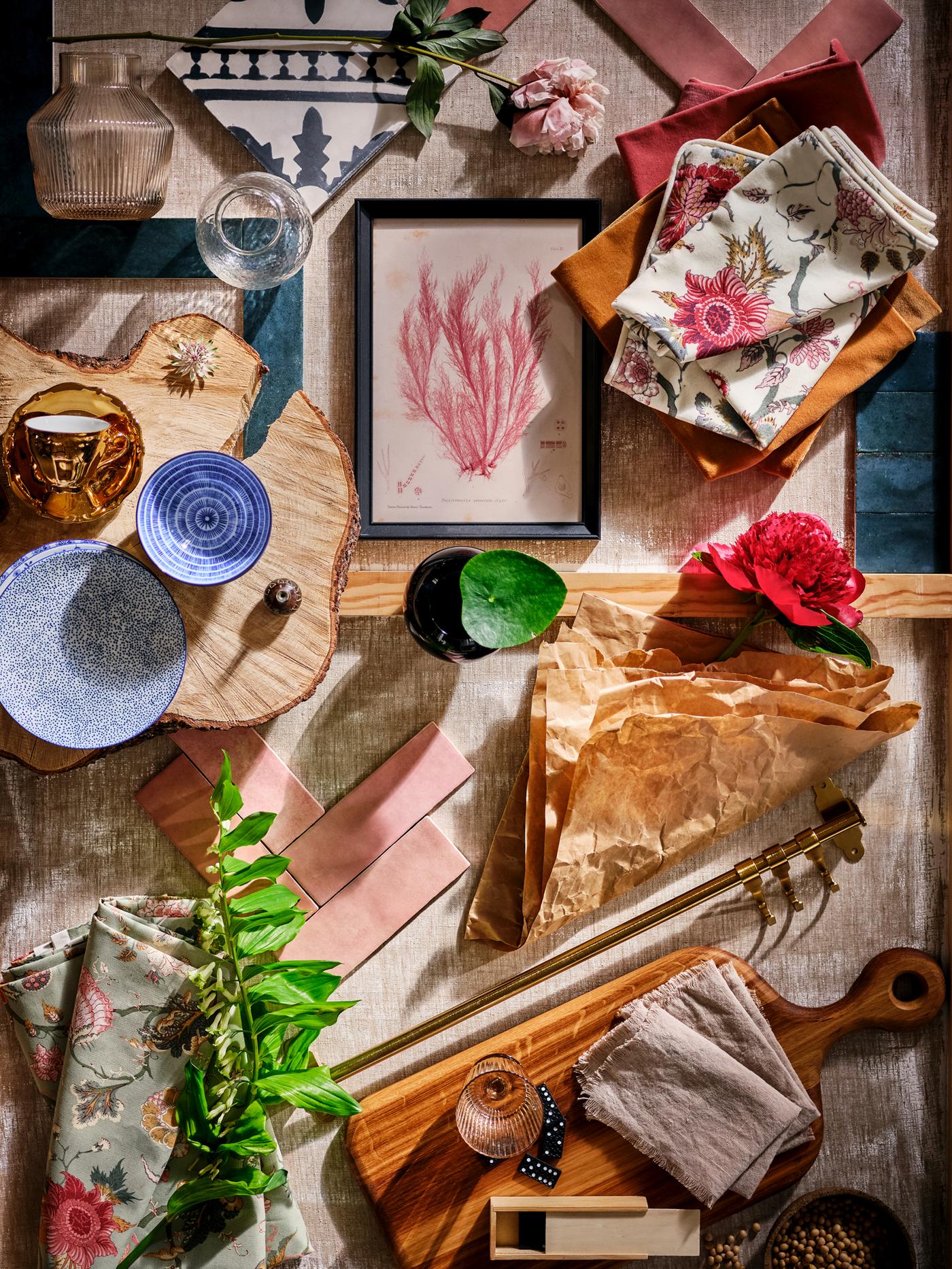 A mood board including patterned ENTUSIASM side plates, pink tiles, wood, textiles, pink flowers and leaves.