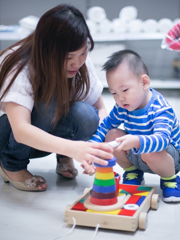 A mother and her child playing with toys at IKEA's children section.