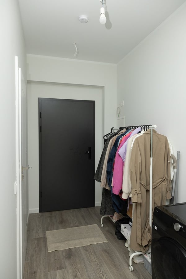 A narrow hallway with a clothes rail and shoes.