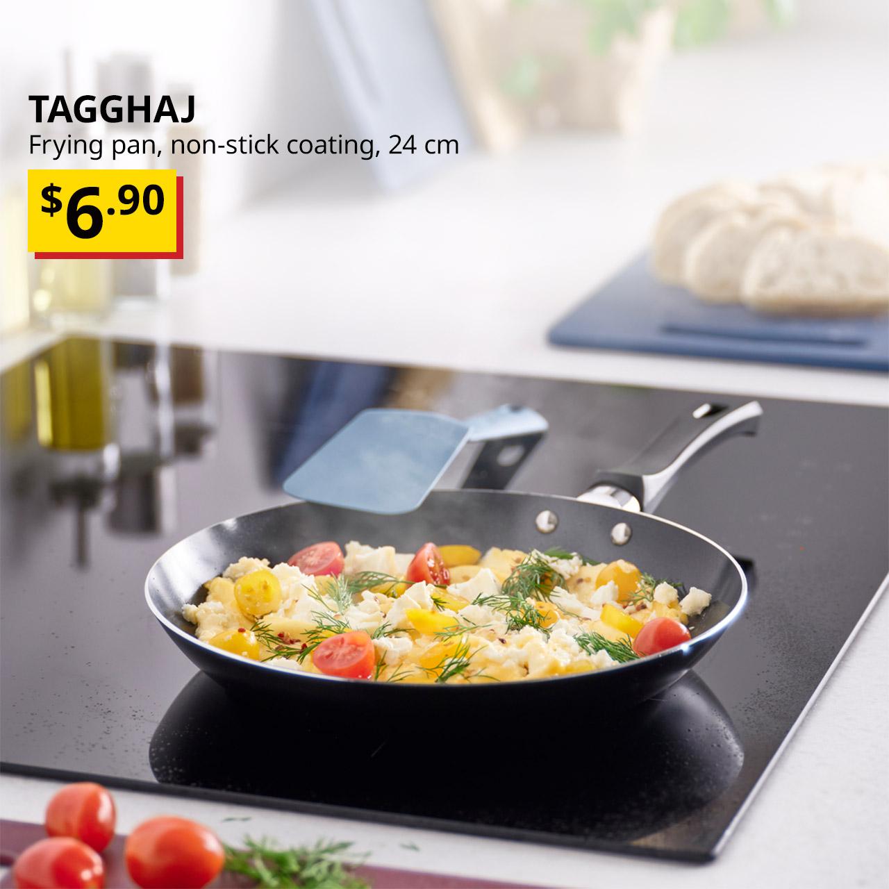 A non-stick coating black TAGGHAJ frying pan on a induction top while vegetables are being stir fried. Text on the top left of the image reads: TAGGHAJ, Frying pan, non-stick coating, 24 cm. Price: $6.90. 