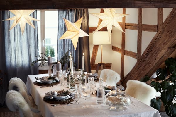 A Nordic winter inspired table decoration, with rustic placemats, candles, and sheepskin.