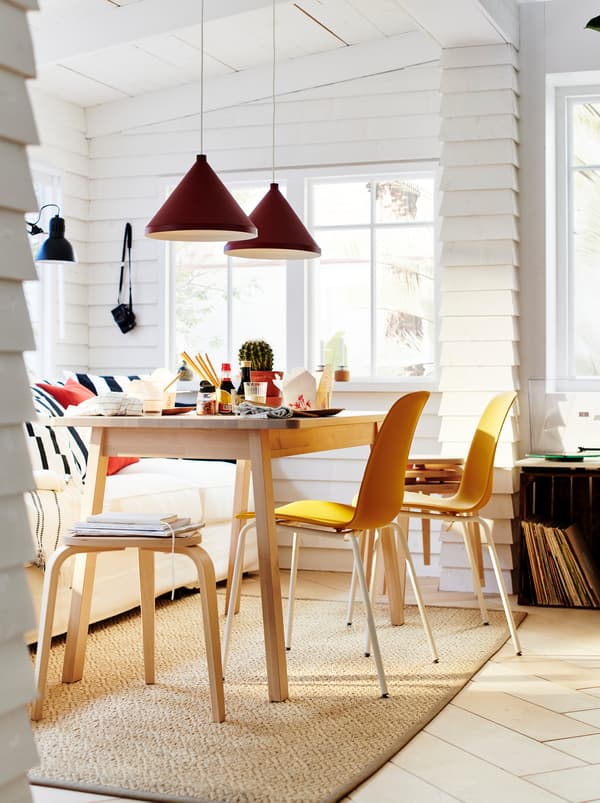 A NORRÅKER table surrounded by LEIFARNE chairs, forming a dining set in a white, sunlit room lined with clapboard walls.