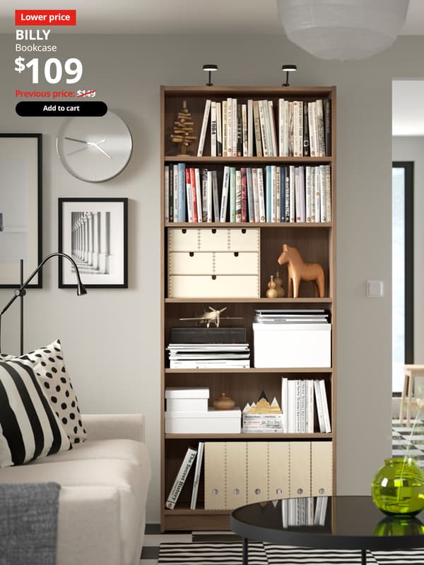 A oak effect BILLY bookcase fill with books in a living room setting. Red 'Lower price' tag with white font on top left of image. White text reads "BILLY, Bookcase, $109." With previous price of $149 slashed.