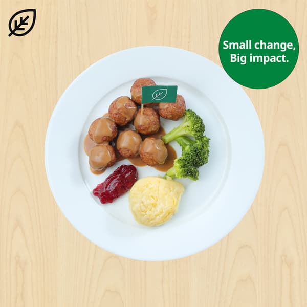 A packet of IKEA HUVUDROLL plant balls placed on a green wooden surface. The packet is surrounded by various ingredients.