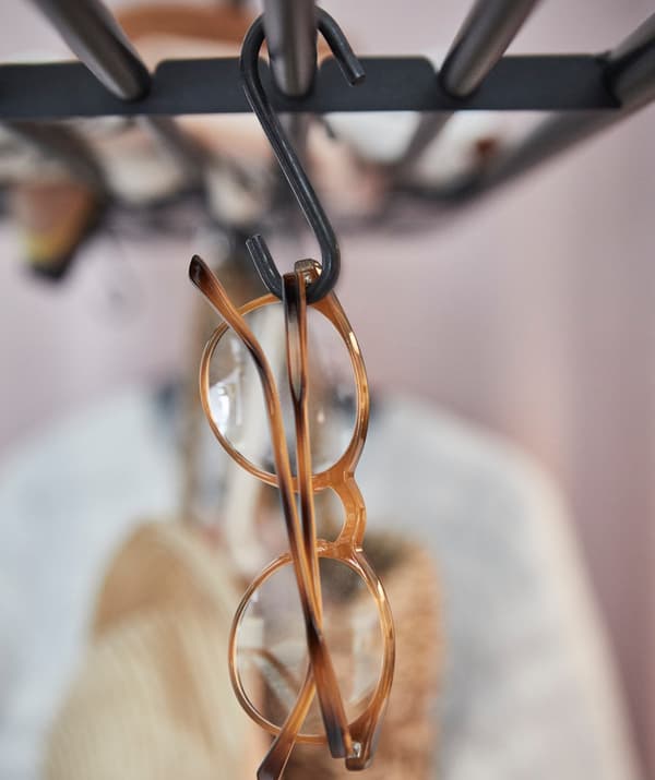 A pair of spectacles hanging on a VADHOLMA rack.