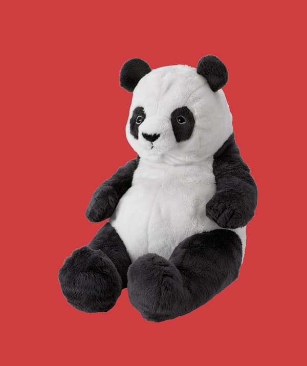 A panda soft toy on a red background.