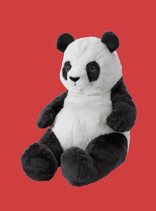 A panda soft toy on a red background.
