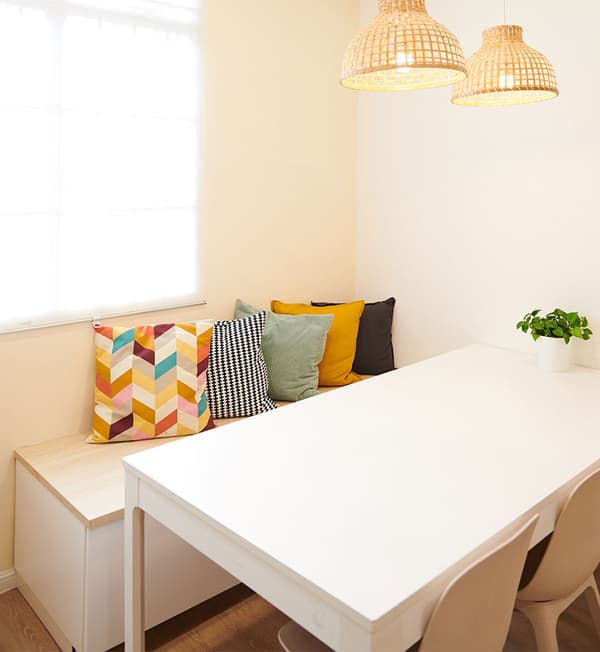 A pantry area featuring a table and a bench with cushions.