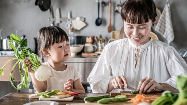 A parent and child happily spending time together in the kitchen.