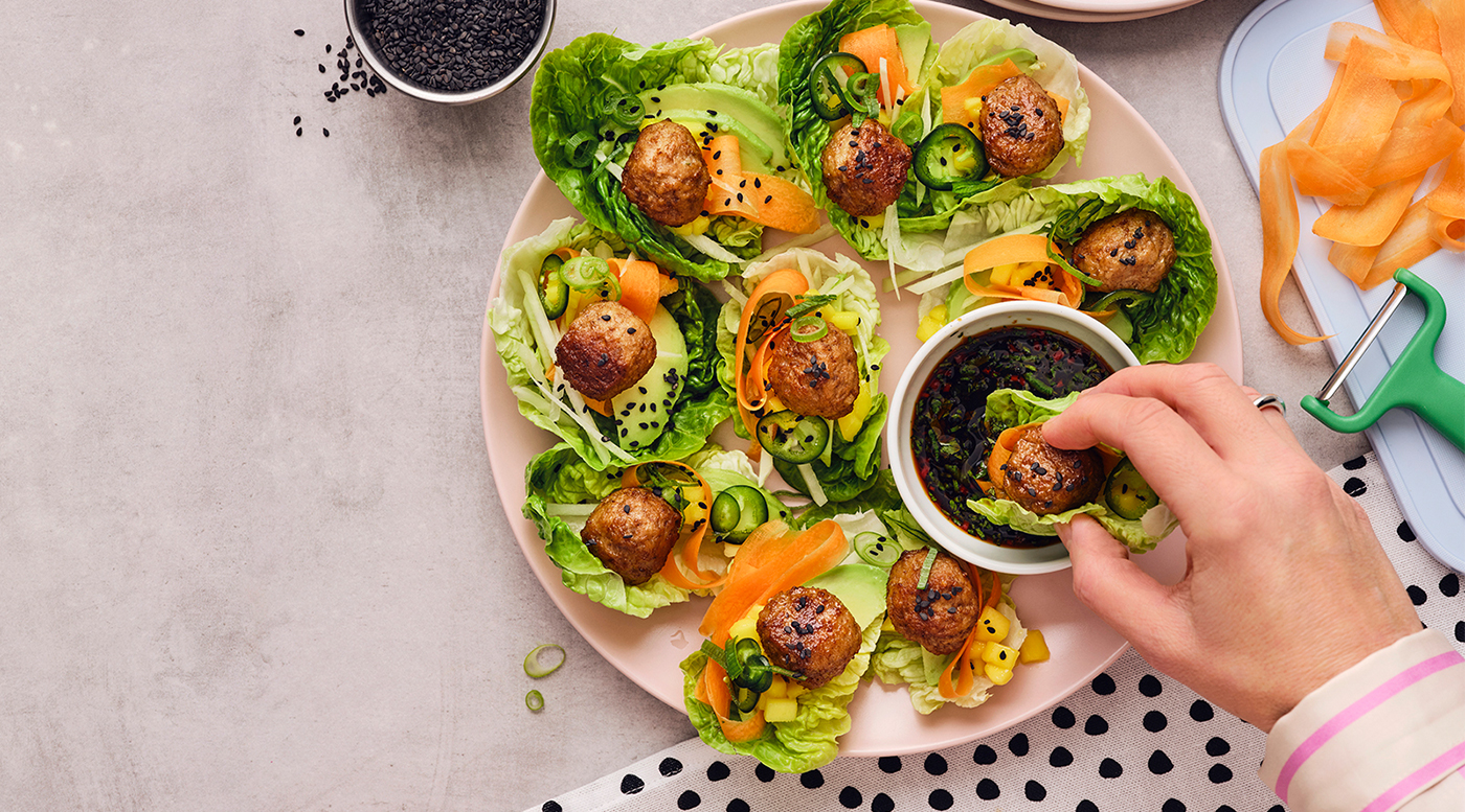 A person dipping some asian wraps into a soy dip