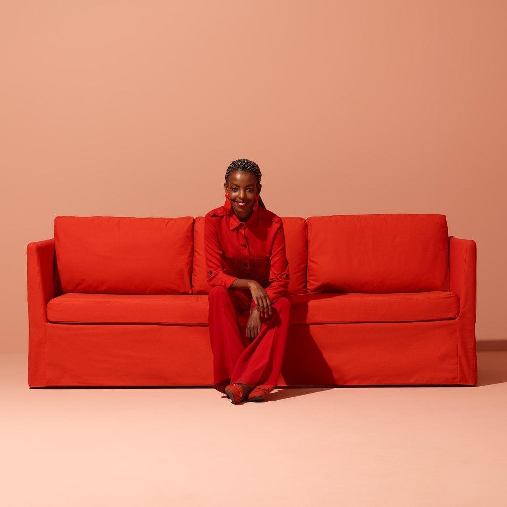 A person dressed in red sitting on a bright red sofa