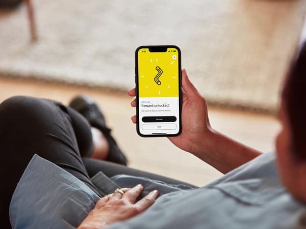 A person holding a mobile phone unlocking an IKEA Family reward.