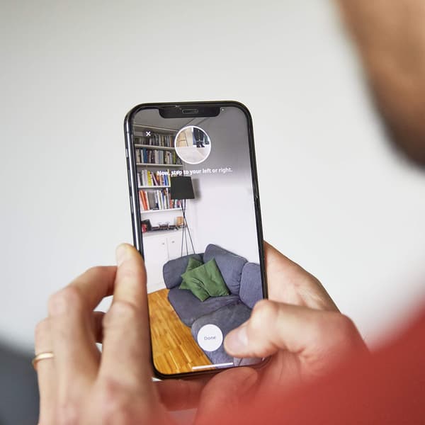 A person holding a phone and scanning their room into the IKEA Kreativ app.