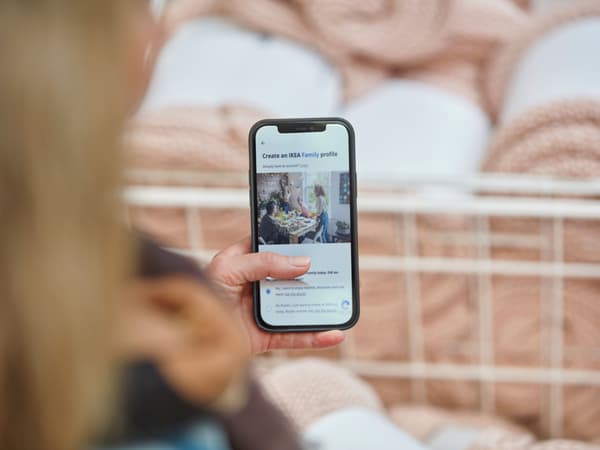 A person holding a phone in a store signing up to IKEA Family.