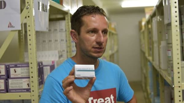 A person holding up a box of medicine.