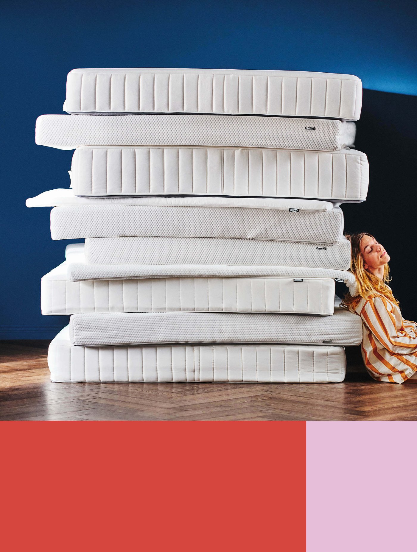 A person leaning against a stack of mattresses