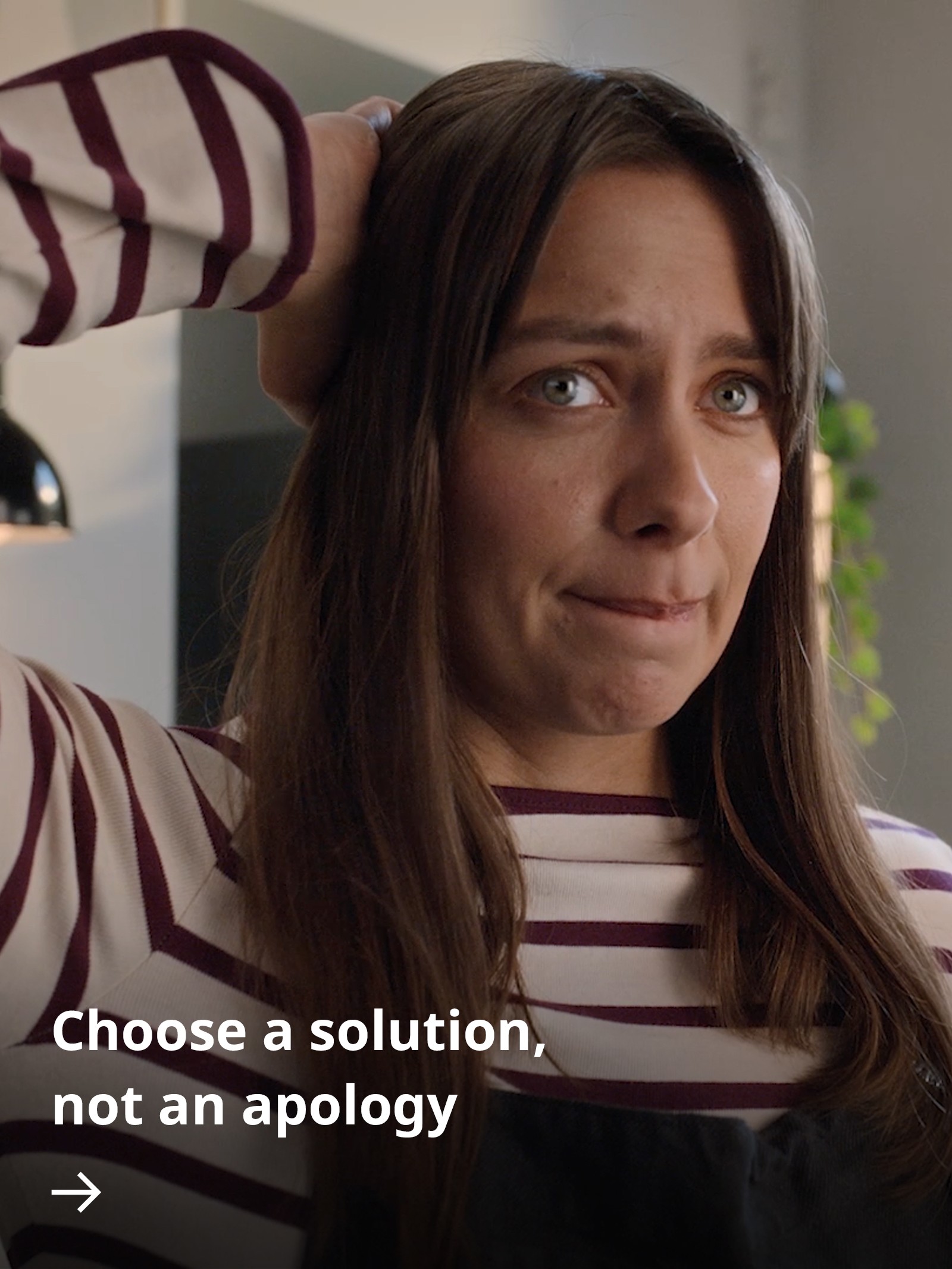 A person looks towards someone with an apologetic expression, appearing uncomfortable and slightly guilty about the state of their home.