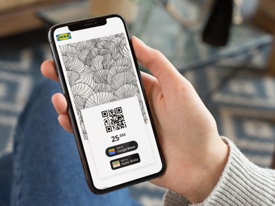 A person on their mobile phone using an IKEA gift card