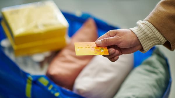 A person paying for a purchase at IKEA with a yellow card.
