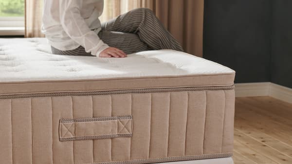 A person sitting on a VATNESTRÖM mattress.
