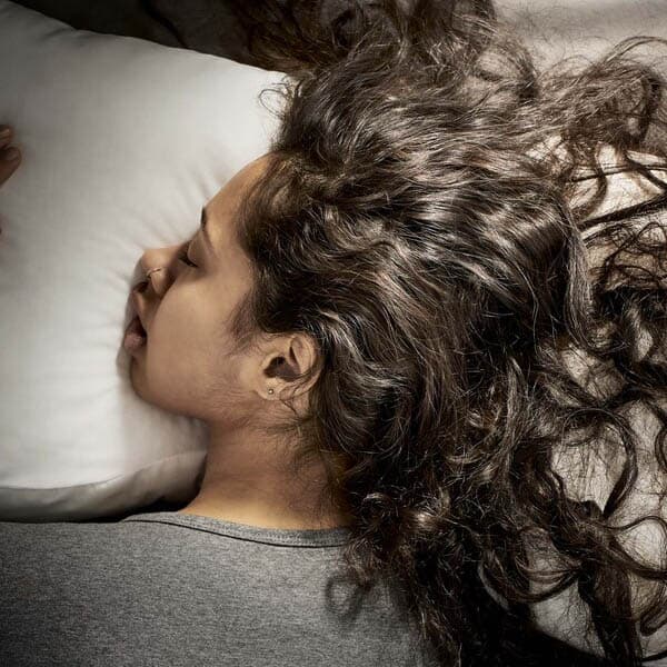 A person sleeping on a pillow. 