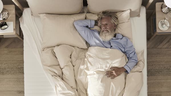 a person sleeping on their back in a bed