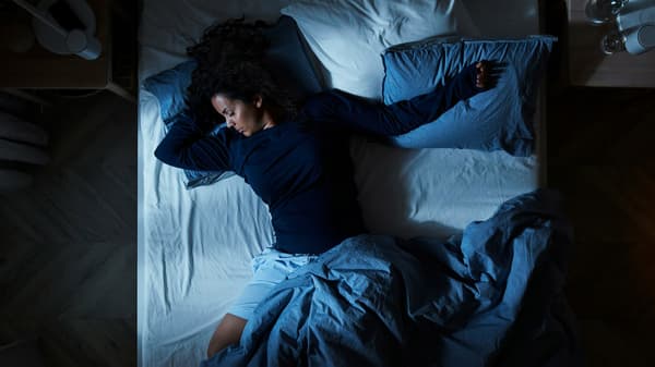 a person sleeping, spawling on their mattress